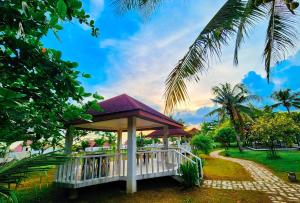 - un kiosque dans un parc avec un palmier dans l'établissement RedDoorz @ Padi Beach Resort Oton Iloilo, à Oton