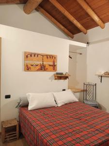 a bedroom with a bed and a painting on the wall at ROSINA HOUSE e CHALET in Colico