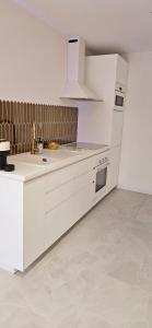a kitchen with white cabinets and a white refrigerator at Douceur Dorée in Yville-sur-Seine