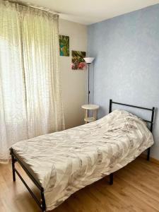 uma cama num quarto com uma cortina e uma janela em Room for women - Room C em Vitry-sur-Seine