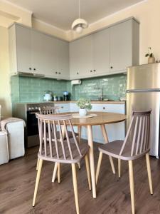 a kitchen with a wooden table and two chairs at Uddo Apartment in Komotini