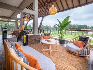 an outdoor patio with chairs and a table at Tarate Loft Studio Ubud in Ubud