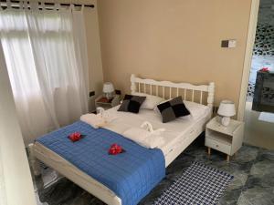 a bedroom with a bed with red flowers on it at Dan Kazou Self Catering in La Digue