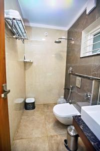 a bathroom with a toilet and a sink at ZIONS HOTEL AND APERTMENT in Devanahalli-Bangalore