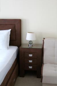 a bedroom with a bed and a nightstand with a lamp at Hotel Opera Jaz in Budva