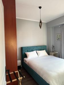 a bedroom with a bed with a green headboard at Uddo Apartment in Komotini