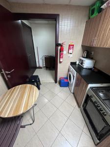 a kitchen with a table and a stove and a microwave at Ladies Hostel in Ajman سكن بنات بعجمان in Ajman 