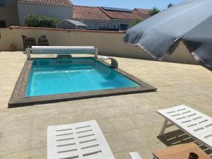 una piscina con ombrellone, tavolo e sedie di Maison avec Piscine privée + Clim proche de la mer a Corneilla-del-Vercol