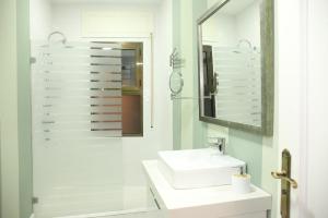 uma casa de banho branca com um lavatório e um espelho em La Parada de Posadas em Posadas