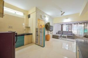 a large kitchen with a couch and a table at EMPYREAN STAY ll 2BHK ll LITTLE HOUSE VILLA ll in Lonavala
