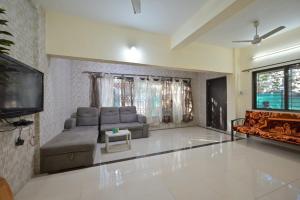 a living room with a couch and a flat screen tv at EMPYREAN STAY ll 2BHK ll LITTLE HOUSE VILLA ll in Lonavala