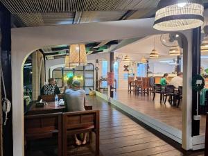 a group of people sitting at a table in a restaurant at PAN Beachfront Resort Krabi in Klong Muang Beach