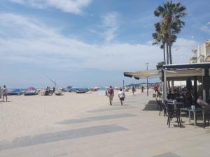 a group of people walking on the beach at Baix a Mar in Torredembarra