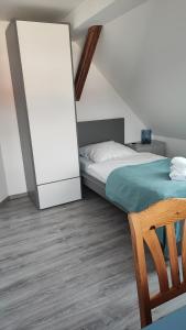 een slaapkamer met een bed en een houten vloer bij Dammstraße 24-DG-ZV38 in Salzgitter