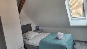 a bedroom with a bed with a blue blanket and a window at Dammstraße 24-DG-ZV38 in Salzgitter