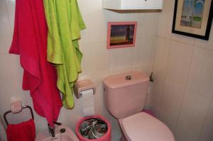 uma casa de banho com um WC rosa e uma toalha vermelha em Precioso dúplex con piscina, en 1ª linea de playa em Puerto de Mazarrón
