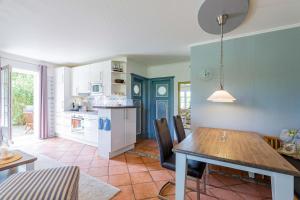 uma cozinha e sala de jantar com mesa e cadeiras em Annes Cottage 2 em Oevenum