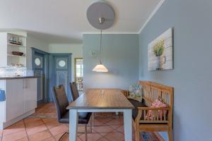 uma sala de jantar com uma mesa e uma cozinha em Annes Cottage 2 em Oevenum