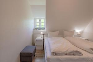 a white bedroom with a bed and a window at Annes Cottage 3 in Oevenum