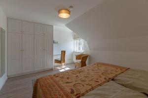 een slaapkamer met een bed en een tafel en stoelen bij Annes Strandhaus in Wyk auf Föhr
