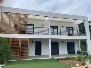 Casa con persianas de madera y balcón. en Les Terrasses de la Pinède - Appt climatisé, en Coti-Chiavari