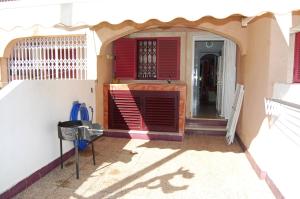 ein Haus mit einer roten Tür und einem Zaun in der Unterkunft Precioso dúplex con piscina, en 1ª linea de playa in Puerto de Mazarrón