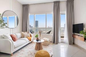un soggiorno con divano bianco e una grande finestra di Silkhaus modern 2BDR with pool and gym near Reem Central Park a Abu Dhabi