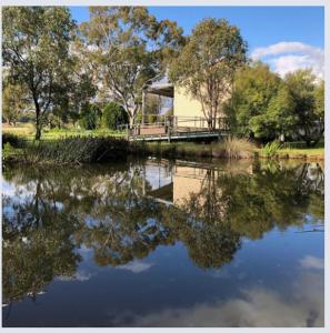 - une vue sur un étang avec une maison et des arbres dans l'établissement Appleyard Bed and Breakfast, à Forbes