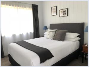 1 dormitorio con 1 cama grande con sábanas y almohadas blancas en Appleyard Bed and Breakfast, en Forbes