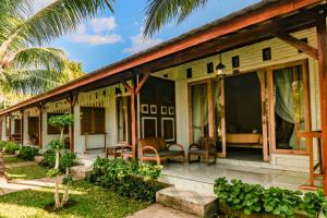 een huis met een veranda met glazen deuren bij Mina Tanjung Hotel in Tanjung