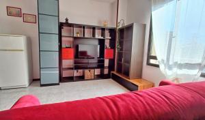 een woonkamer met een rode bank en een tv bij Casa Usignolo in Perugia