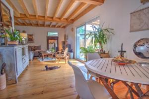 uma sala de estar com mesa e cadeiras em Gite de charme Bassin d'Arcachon- Piscine-Proche des plages-Au calme em Gujan-Mestras