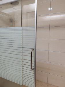 a shower with a glass door in a bathroom at Hotel Prima in Sandakan