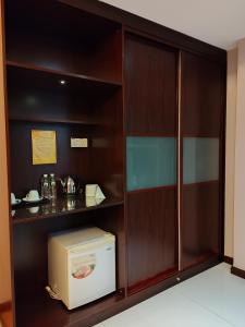 cocina con armarios de madera y microondas en Hotel Prima en Sandakan