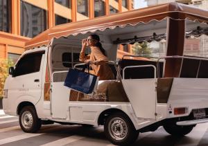 a woman talking on a cell phone in a van at SAMALA Hotel Bangkok in Bangkok