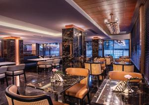 バンコクにあるSAMALA Hotel Bangkokのテーブルと椅子が備わるレストラン