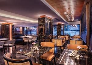 a restaurant with tables and chairs in a room at SAMALA Hotel Bangkok in Bangkok