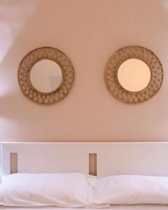 2 espejos en la pared sobre una cama en Suite.delpozzo, en Capurso