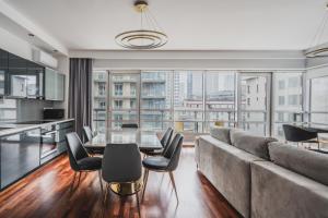 uma sala de estar com um sofá, uma mesa e cadeiras em Platinum Towers J&K em Varósvia