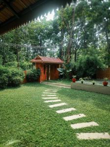 een tuin met een stenen pad voor een gebouw bij ATHIRAPPILY SREENILAYAM HERITAGE RESORt in Athirappilly