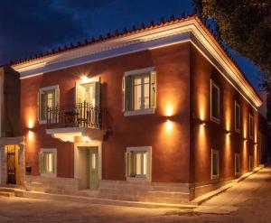 un edificio de ladrillo rojo por la noche con luces en Chora Aegina's Apartments, en Aegina Town