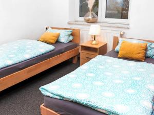 una camera da letto con due letti e un tavolo con una lampada di Rentarooms B a Oebisfelde