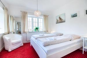 フレンスブルクにあるfewo1846 - Kapitänsvilla - luxuriöse Stadtvilla mit 4 Schlafzimmernの白いベッドルーム(ベッド2台、シャンデリア付)