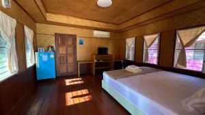 - une chambre avec un lit dans une pièce dotée de fenêtres dans l'établissement อิงน้ำท่าจีน (ท่าจีนรีสอร์ท), à Suphanburi