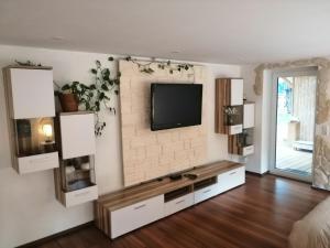 a living room with a television on a wall at Ferienwohnung Hecht - Biketrail Fun & Relaxing in Wolfegg +17 photos
