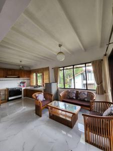 ein großes Wohnzimmer mit Sofas und einer Küche in der Unterkunft De Marlin's Garden Villa by GroRental in Tegalharendong