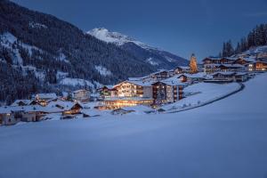 un pueblo en la nieve por la noche en Alpenwellnesshotel Gasteigerhof, en Neustift im Stubaital