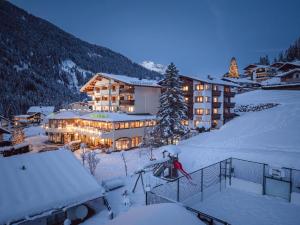 a large building in the snow at night at Alpenwellnesshotel Gasteigerhof in Neustift im Stubaital