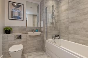 e bagno con doccia, servizi igienici e lavandino. di SUPERIOR AIRPORT SUITE, FREE Parking, Stylish, BALCONY, Two Bathrooms, Close To Airport, Station & Centre a Luton