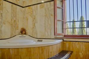 bañera grande en una habitación con ventana en Podere Viepri - Villa in esclusiva nei Colli Senesi con Vasca idromassaggio, en Serre di Rapolano